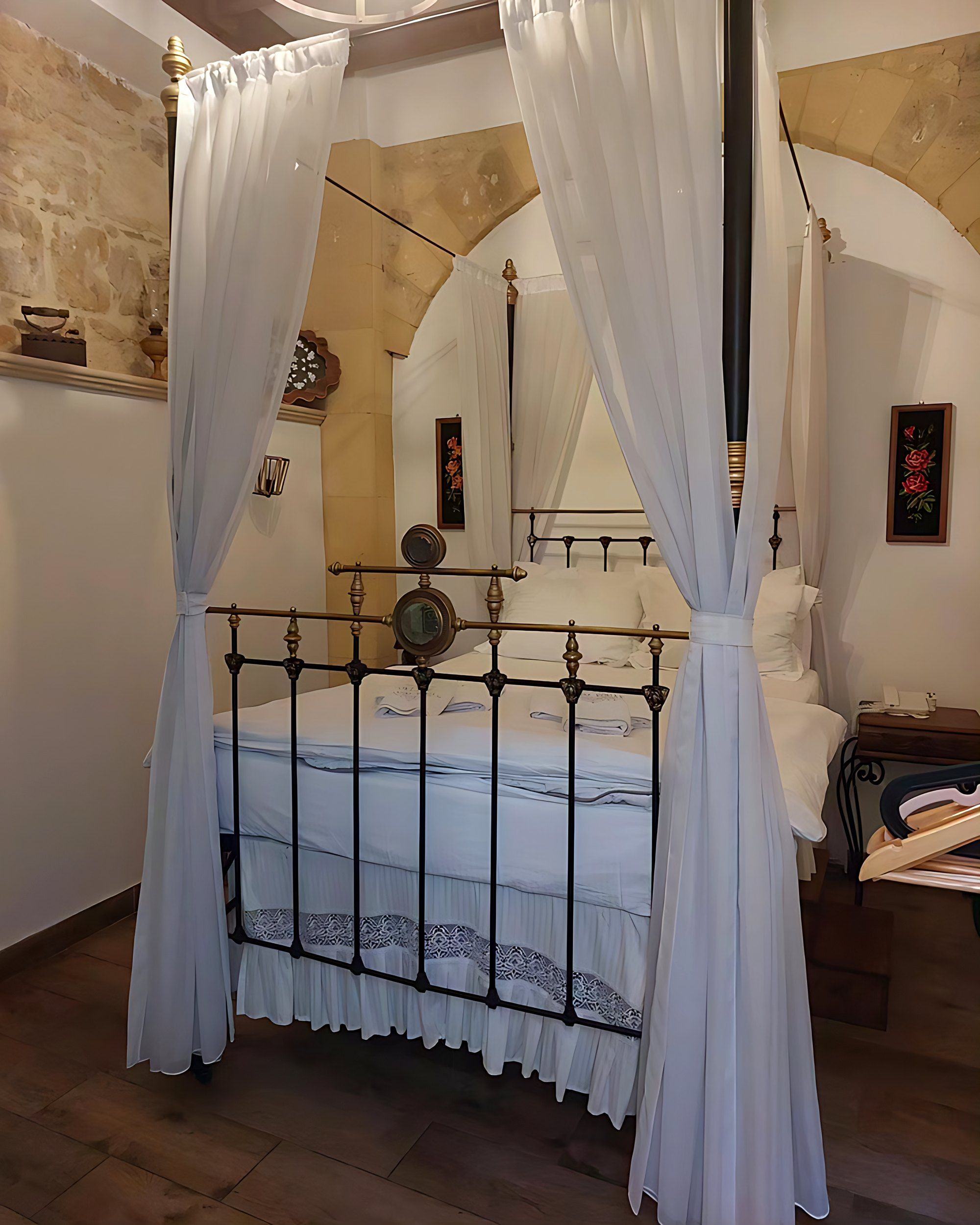 Iron bed with white drapes