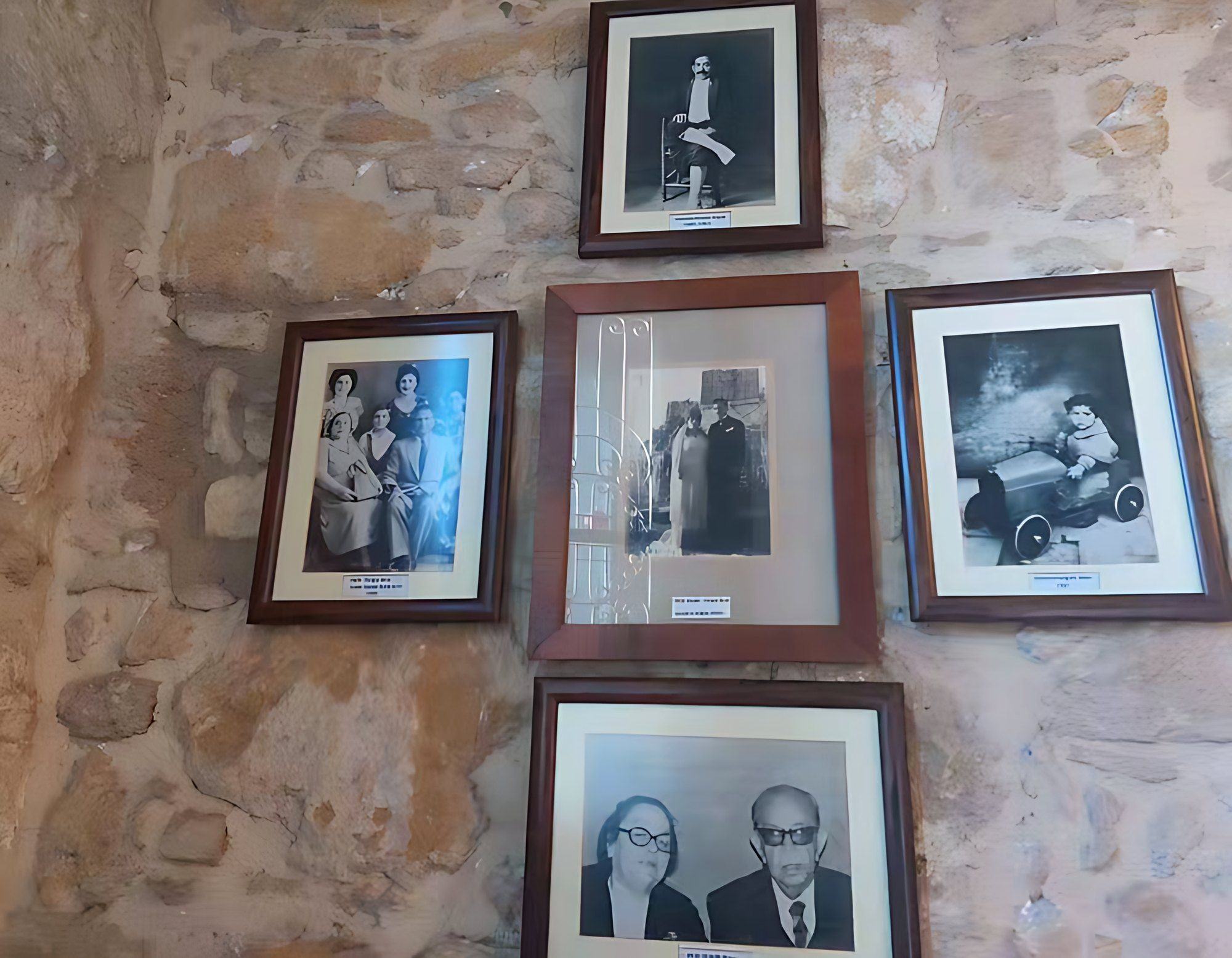 Framed family photographs on the stone wall of the konak
